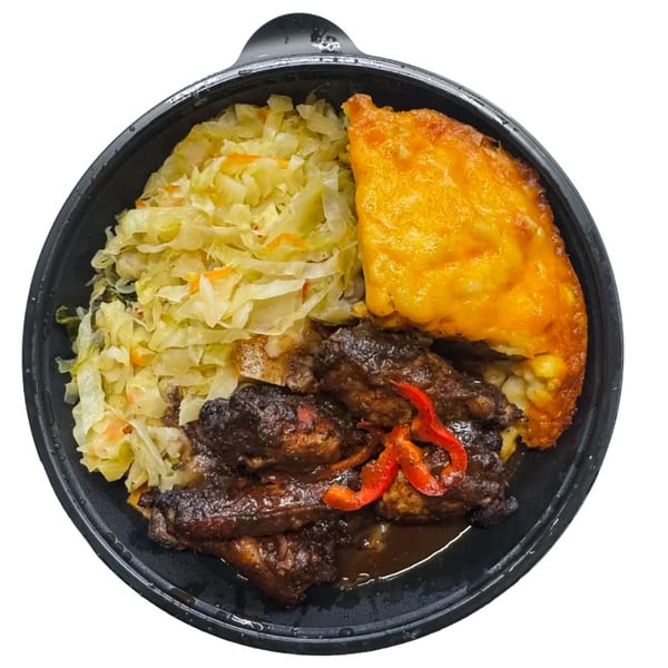 Jerk chicken, steamed cabbage, and baked mac and cheese in a black takeout container.